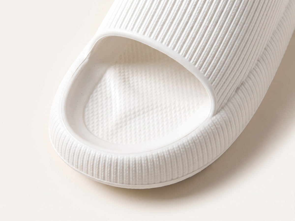 Top-down close-up of the textured footbed and raised rim of a white Again Recovery Slide
