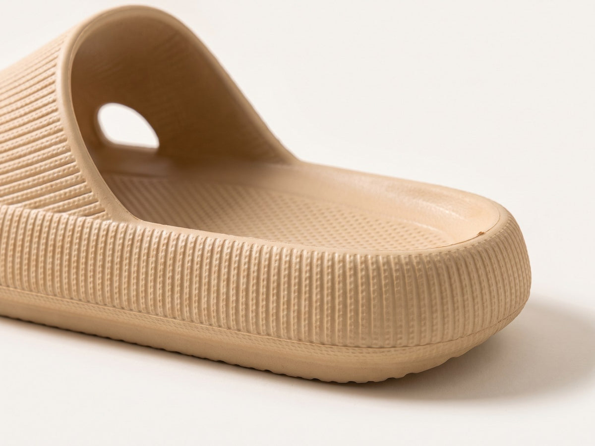 Side close-up of the thick, rounded, ribbed sole of khaki Again Recovery Slides