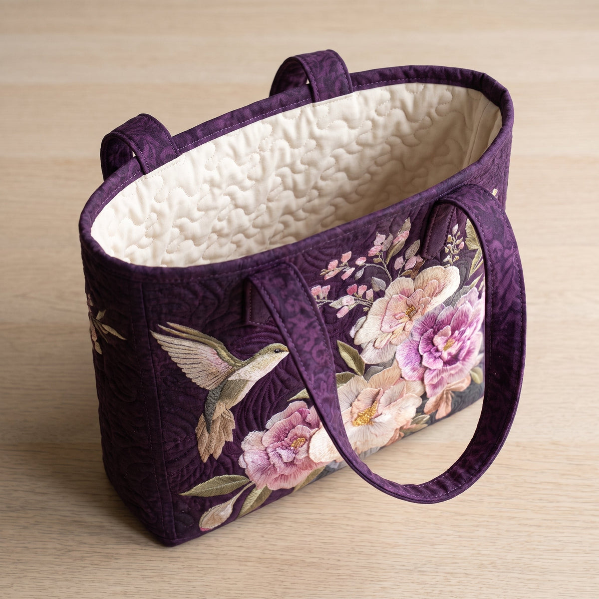 Artisanal Quilted Bag - Hummingbirds and Orchids — open, showing the plain cream quilted lining