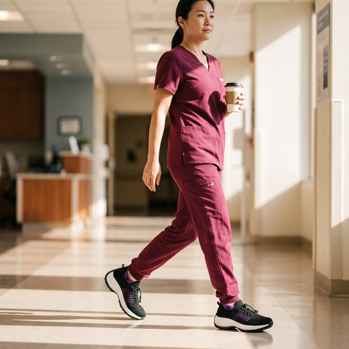 Again Glide in Black / Purple, worn by a nurse in wine scrubs walking the corridor